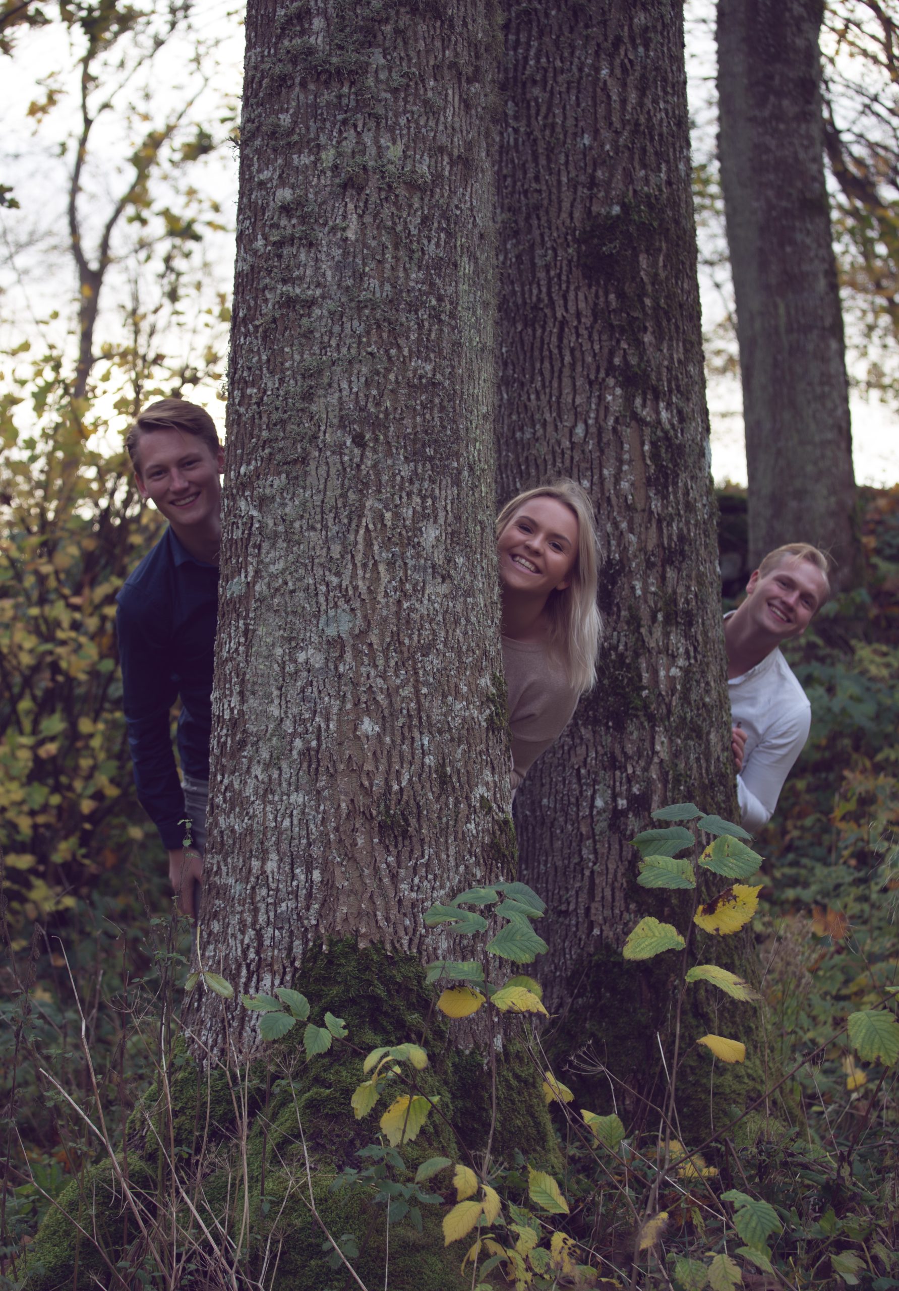 Varm och kärleksfull familjefotografering i en naturlig utomhusmiljö, fångad i en tidlös svartvit stil. Familjen delar ett ömt ögonblick tillsammans, med lekfulla uttryck och närhet. Fotograferad av Fotograf Frida Hansson, verksam i Tvååker, Varberg.